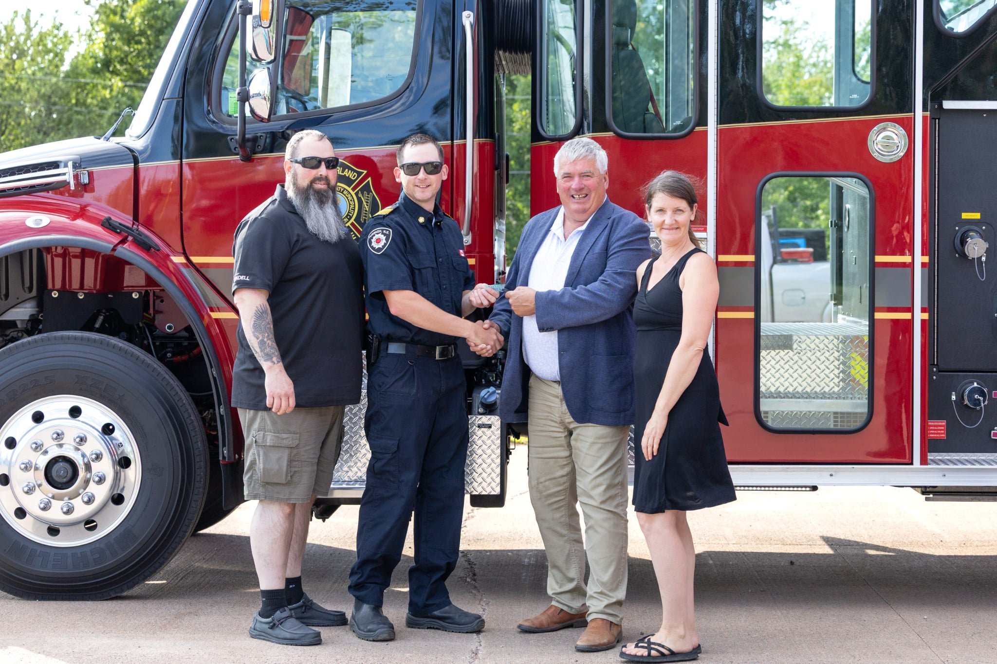 People stand in front of a new fire truck